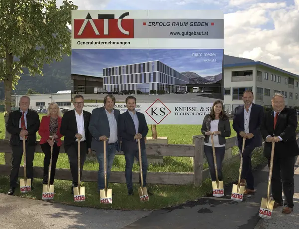 Spatenstich vor Bautafel