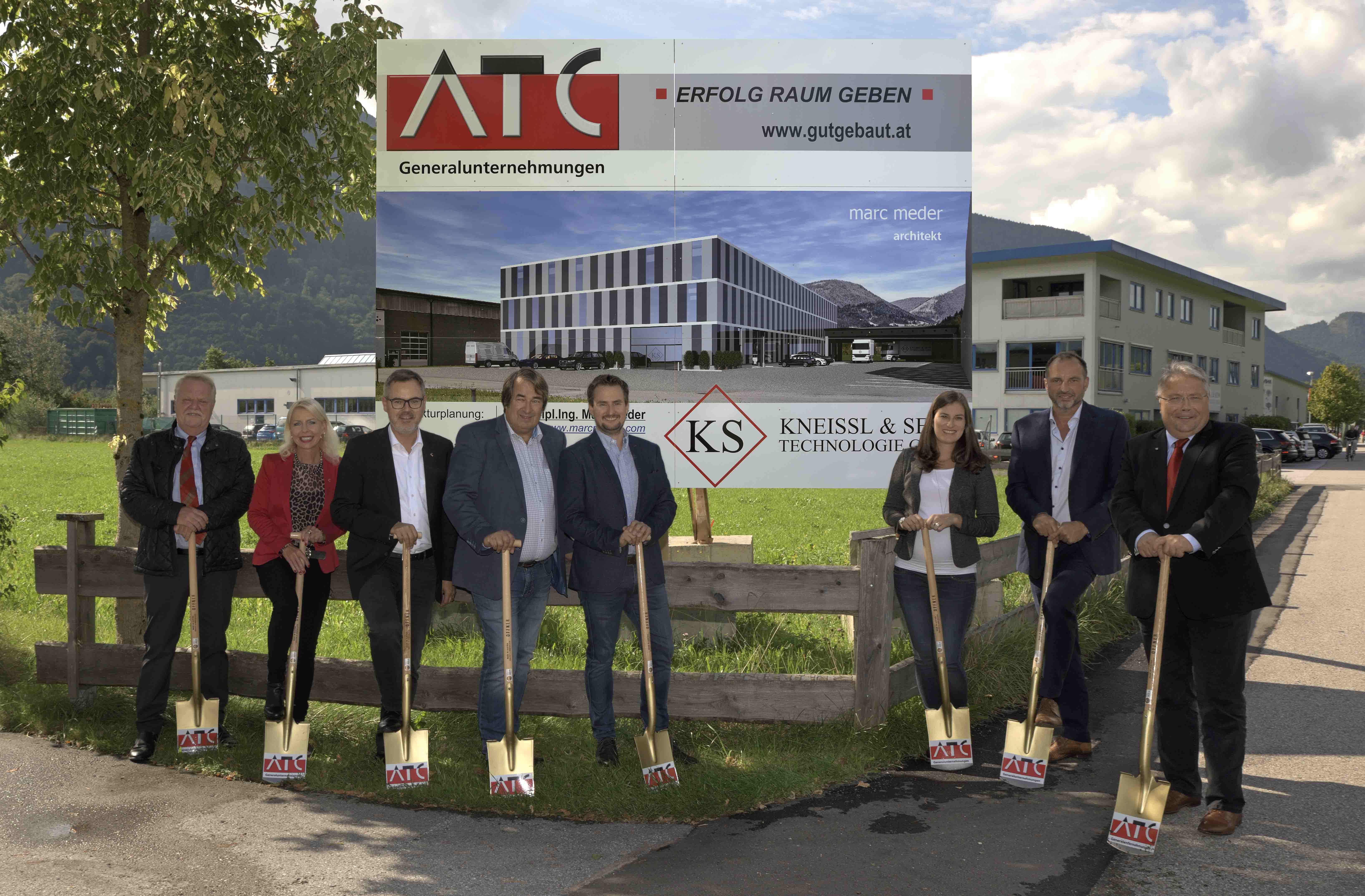 Spatenstich vor Bautafel